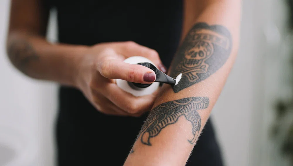 Aplicando crema hidratante sobre un tatuaje. Cómo cuidar un tatuaje