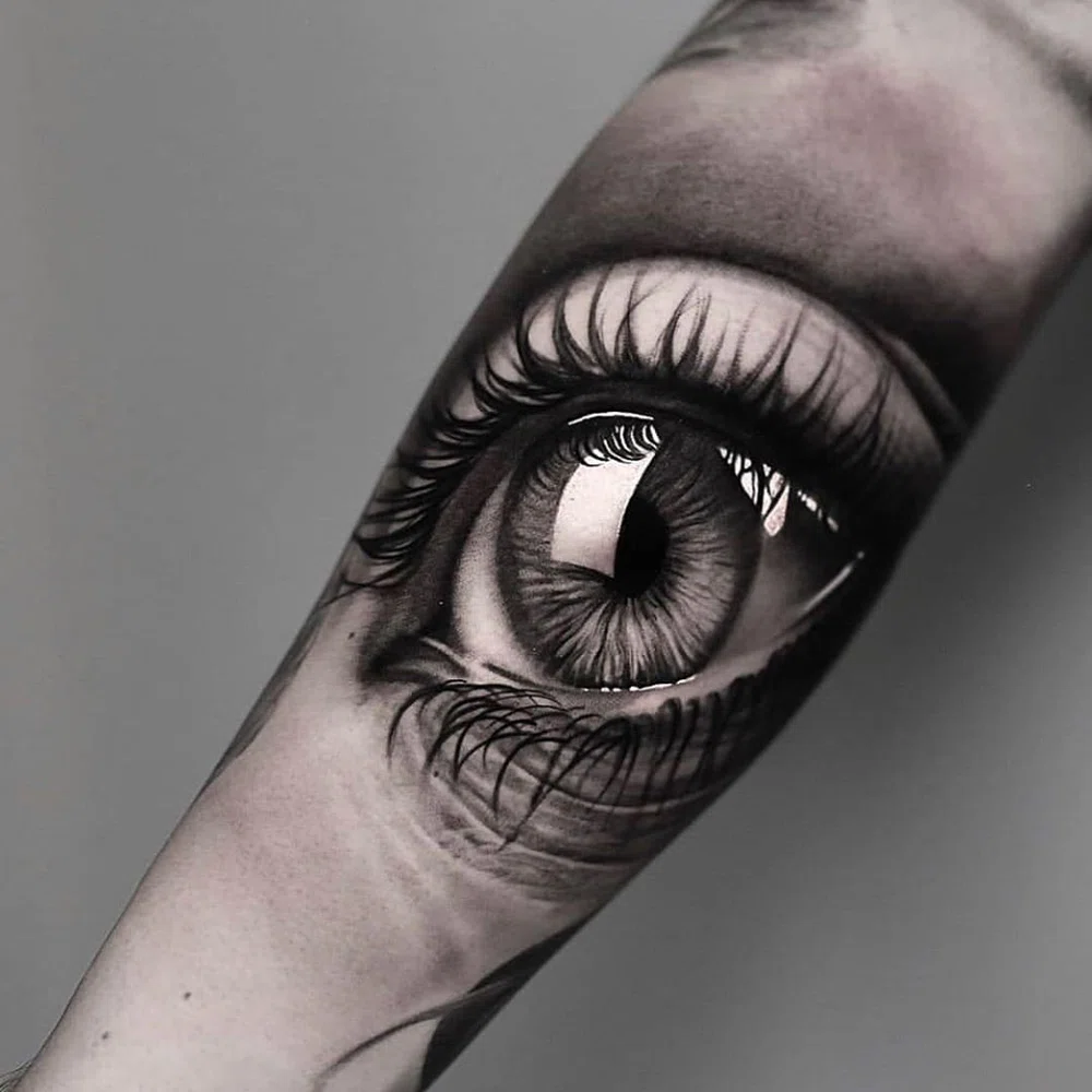 Tatuaje realista de un ojo. Tatuaje en blanco y negro.